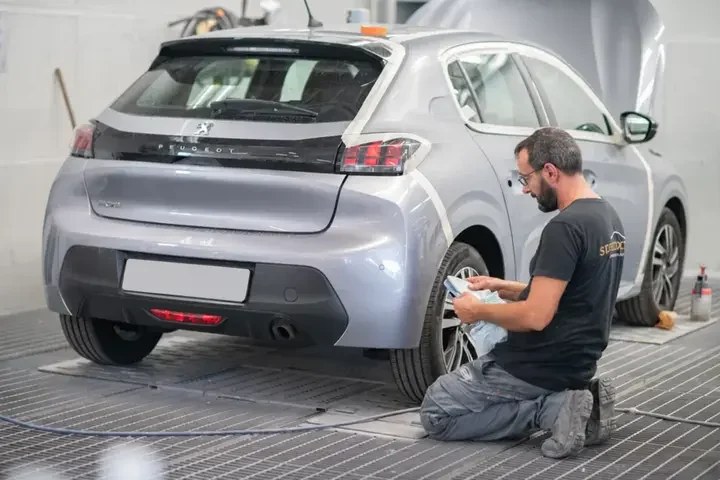 Tecnico al lavoro sullo pneumatico di un’auto